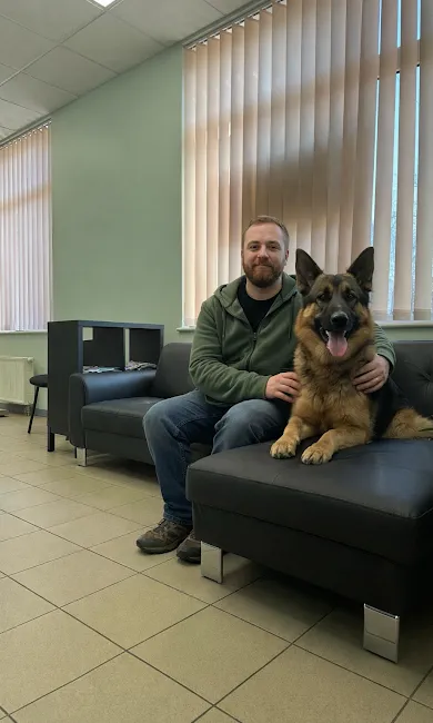 Saimnieks ar vācu aitu suni uzgaidāmajā